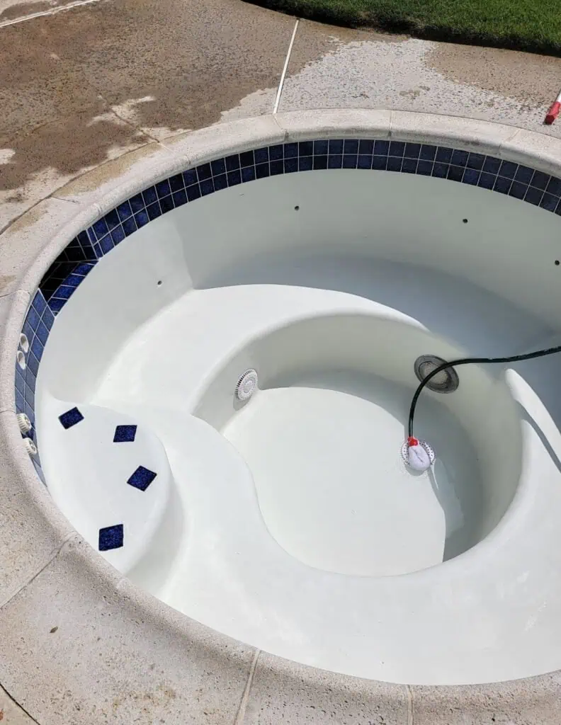 New white pool with blue tile accents, ready for filling.