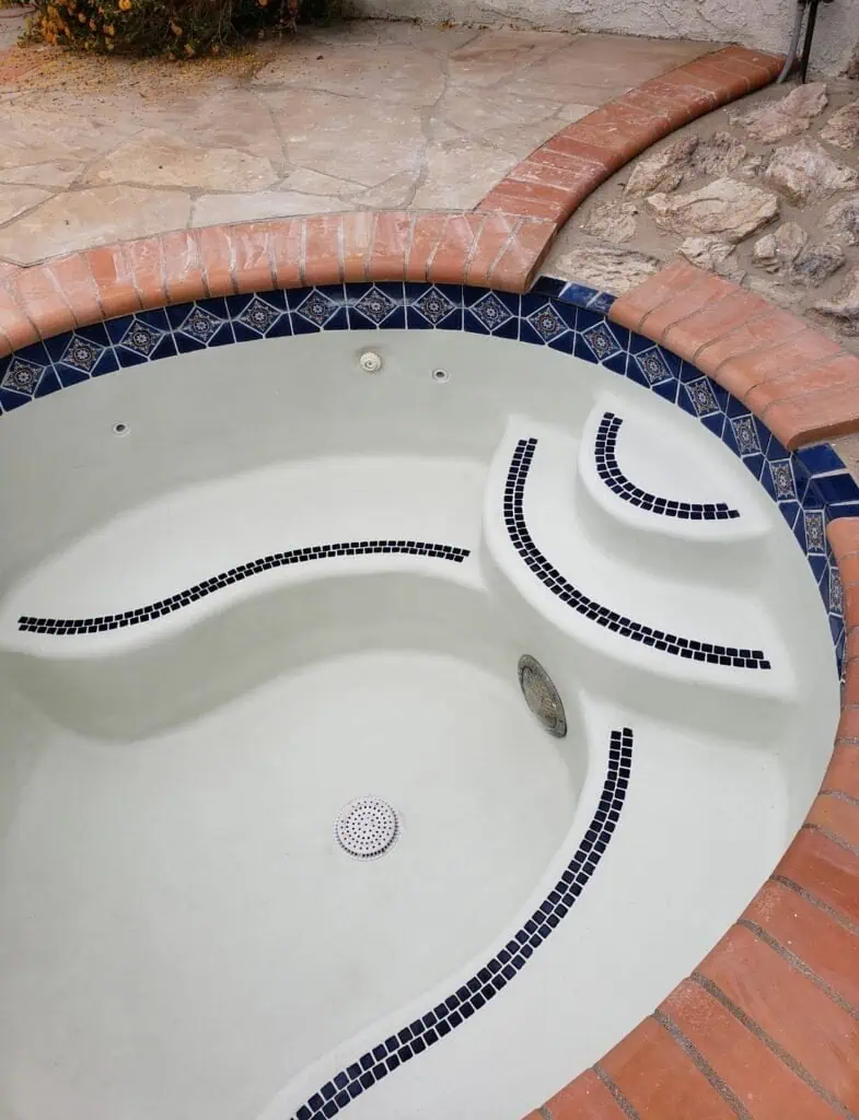 Pool plastering with custom mosaic tile accents for a luxurious backyard pool.