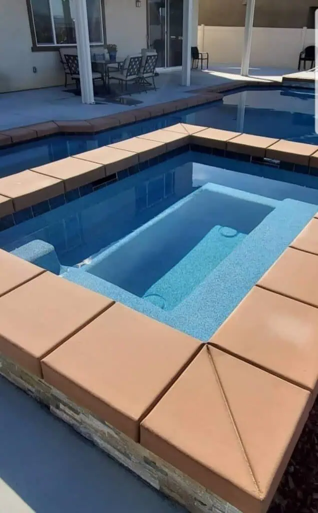 Custom pool with smooth plaster finish and tiled edges in backyard.