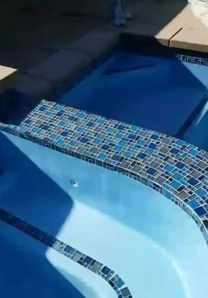 Custom pool plastering with mosaic tile accents for a luxurious backyard pool.