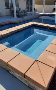 Pool with tiled edges and smooth plaster finish, showcasing professional pool plastering services in a residential backyard. Custom pool with smooth plaster finish and tiled edges in backyard.