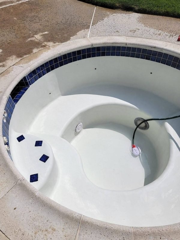 New white pool with blue tile accents, ready for filling.