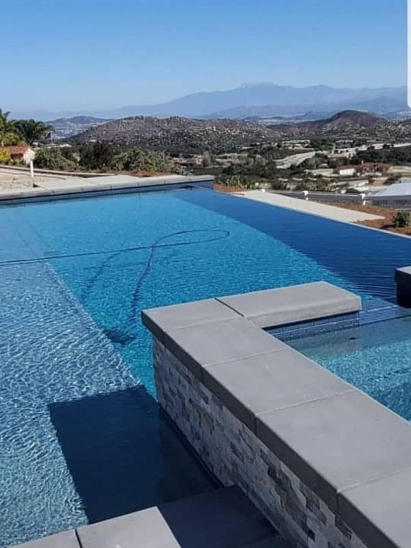 Modern backyard pool with sleek design and mountain backdrop.