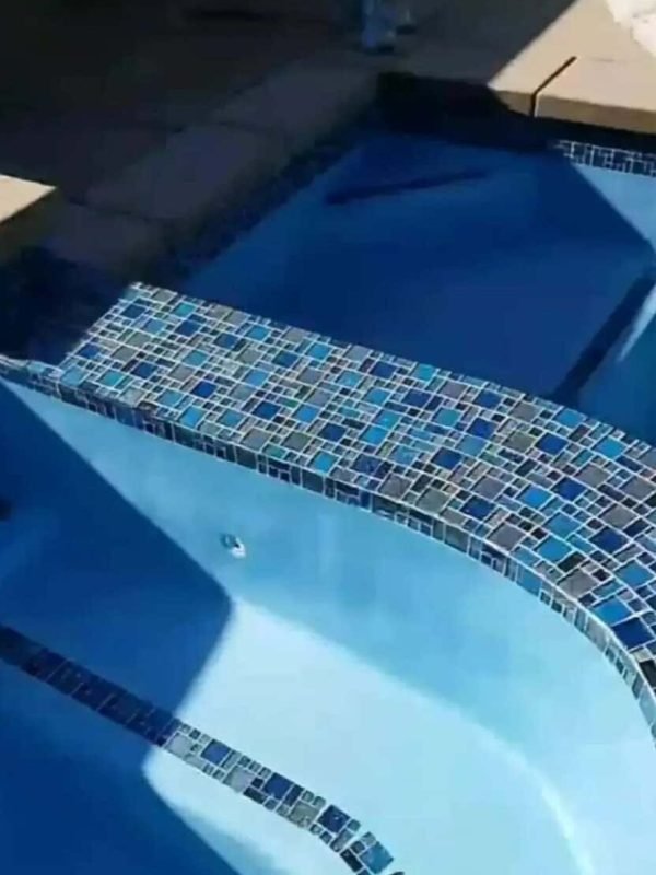 Custom pool plastering with mosaic tile accents for a luxurious backyard pool.